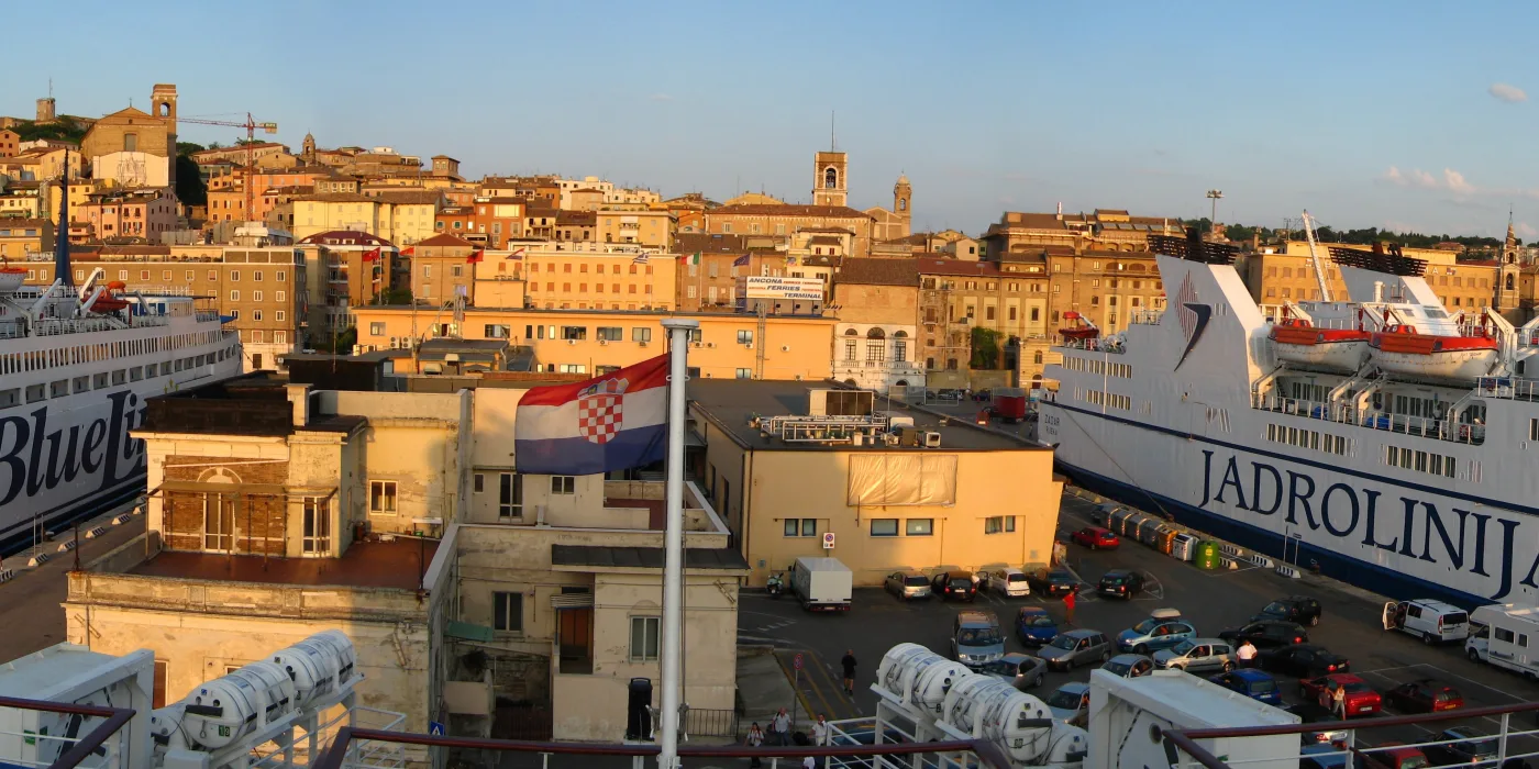 Hafen von Ancona im Abendlicht: Fährschiffe an den Anlegern, dahinter die ansteigende Altstadt.