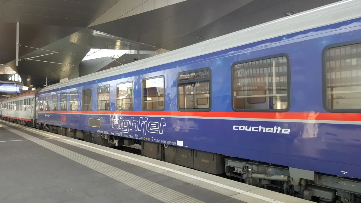 Blauer Nightjet-Liegewagen mit der Aufschrift &bdquo;couchette&ldquo; am Bahnsteig.